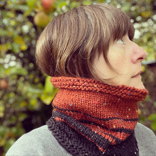 Nicky wearing a burnt orange and black striped knitted cowl